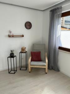 a chair with a red pillow sitting next to a window at RheinSchatz Apartments 3 in Oberwesel