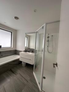 a bathroom with a shower and a sink at Easy Beach Holiday in Mount Maunganui