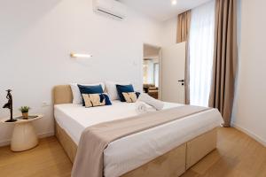 ブカレストにあるCentral Suitesの大きな白いベッドと青い枕のある寝室