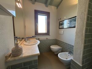 a bathroom with two sinks and a toilet and a window at Casa Giumagio by Holiday World in Posada