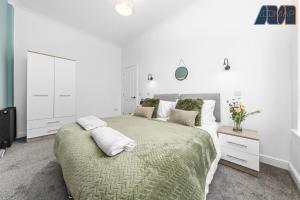 a bedroom with a large bed with a green blanket at 2 Bed Home with Parking Sleeps 4 in Fife