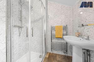 a white bathroom with a shower and a sink at 2 Bed Home with Parking Sleeps 4 in Fife +20 photos