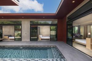 Sunday Sea Two Pool Villa Pattaya في جومتين بيتش: منظر خارجي لمنزل به حوض سباحة