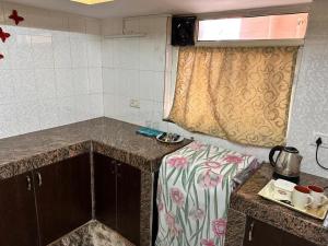 a small kitchen with a table and a window at James Guesthouse in Bogmalo