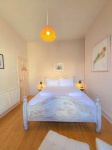 Un dormitorio con una gran cama blanca en una habitación. en Central Wellington Apartment with Courtyard, en Hastings