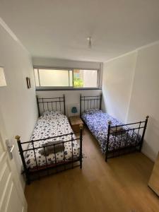 ラモンビル・サン・タニュにあるT3 atypique au rez de chausséeのベッド2台と窓のある寝室