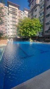 a large blue swimming pool in front of some buildings at Cozy 2bedrooms Matina Enclaves condo in Davao City