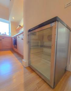 una gran nevera de cristal en una cocina con suelo en Central Wellington Apartment with Courtyard, en Hastings