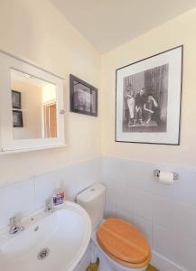 Un baño con un inodoro blanco y un lavabo. en Central Wellington Apartment with Courtyard, en Hastings