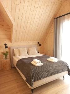 a bedroom with a bed with two towels on it at Domek z bali Zakopane in Zakopane