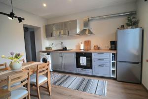 a kitchen with a table and a stainless steel refrigerator at Tiigi Apartment Enjoy City Center Stay with Free Bikes and Self Check-in in Kärdla