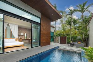 Sunday Sea Two Pool Villa Pattaya في جومتين بيتش: منزل به مسبح وغرفة نوم
