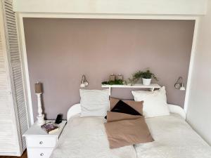 une chambre avec un lit blanc avec des oreillers blancs dans l'établissement Ferienhof-Wohler-Wohnung-1, à Bojendorf