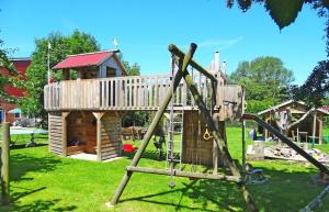- une aire de jeux avec une cabane dans les arbres dans la cour dans l'établissement Ferienhof-Wohler-Wohnung-1, à Bojendorf