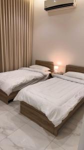 two beds sitting next to each other in a bedroom at Hotel Apartment - 4 - LAvner Al hussma in Quai +5 photos