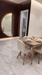 a dining room with a table and chairs and a mirror at Hotel Apartment - 4 - LAvner Al hussma in Quai