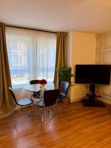 a living room with a table and chairs and a television at 2 Bedroom Apartment near Glasgow City Centre, Celtic Park and Emirates Arena in Glasgow