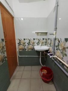 a bathroom with a sink and a shower with flowers on the wall at JasLittleWood Palace in Madurai