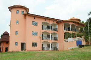 un bâtiment orange avec des balcons sur une pelouse dans l'établissement Le gîte d'Allizon - Etage 2, à Banda