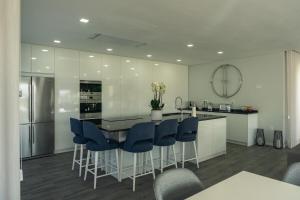 a kitchen with a island with blue chairs and a counter at Vietnam House in Barcelos