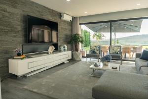 a living room with a large tv on a brick wall at Vietnam House in Barcelos