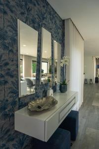 a bathroom with a mirror and a vanity with a sink at Vietnam House in Barcelos +33 photos
