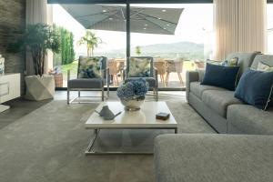 a living room with a couch and chairs and an umbrella at Vietnam House in Barcelos
