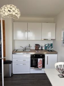a kitchen with white cabinets and a stove top oven at The Fisherman's Snug self catering North Uist in Paible