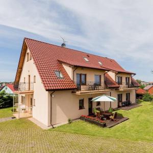 a white house with a red roof and a patio at Tasarz 2 in Rewal +5 photos