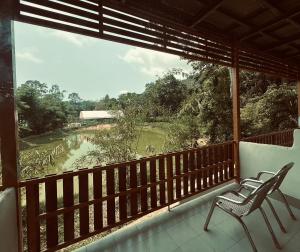 a balcony with two chairs and a view of a river at Koh Chang Cabana Resort with swiming pool in Ko Chang