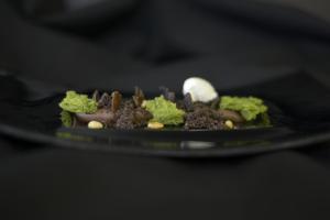 a plate of food on a black plate at Logis Hotel Restaurant Au Boeuf Rouge in Niederschaeffolsheim