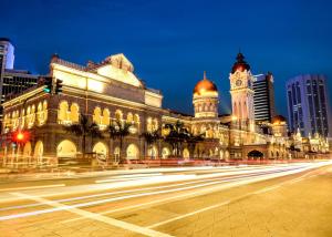 クアラルンプールにあるエ－シスホテル、クアラルンプール　の時計塔と通りを持つ建物