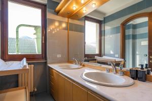 a bathroom with two sinks and two mirrors at La Grande Valsassina in Pasturo +61 photos