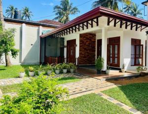 a house with a garden in front of it at Sithuka Villa Bentota in Bentota