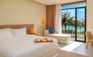 ニャチャンにあるSUNNY - Resort Villas & City Apartmentsのベッドと椅子のあるホテルの部屋