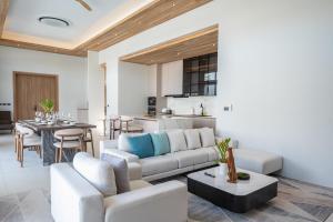 a living room with a couch and a table at Mouana Breeze Mai Khao VIP 4-bedroom Pool Villa 9911 in Phuket