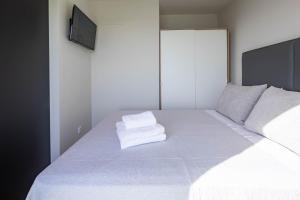 ポブラ・ド・カラミニャルにあるBungalow 2 con piscina en la playaの白いベッド(タオル2枚付) +12枚の写真