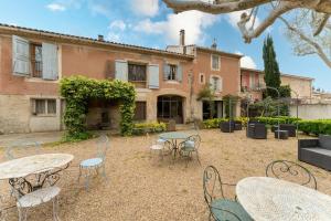 a courtyard with tables and chairs in front of a building at Le Mas Saint Pierre in Cabannes