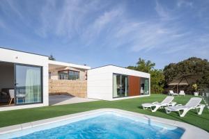 ポブラ・ド・カラミニャルにあるBungalow 2 con piscina en la playaの庭にスイミングプールがある家