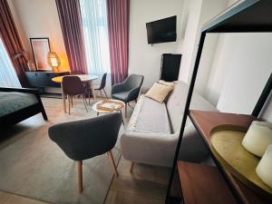 a hotel room with a couch and a table and chairs at Sopot C 200m do plaży in Sopot