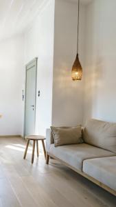 a white living room with a couch and a table at LIVIN Hydra Duplex Suite in Hydra