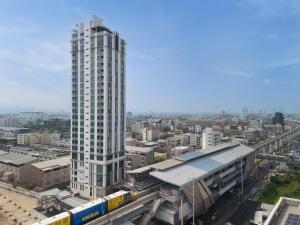 a tall building in a city with a train station at Lumen Bangkok Srinakarin in Bangkok