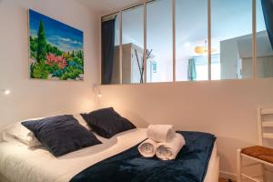 a bedroom with two beds and a large window at Les Flots de la Marle - Avec parking couvert in Vannes