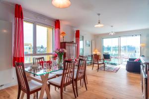 a dining room and living room with a table and chairs at Les Flots de la Marle - Avec parking couvert in Vannes