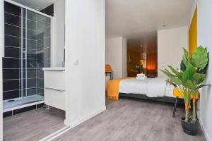 Un dormitorio con una cama y una ventana grande en NG Prestige - Suite Soleil Doré - Balnéo - Cuisine - Jardin, en Roubaix