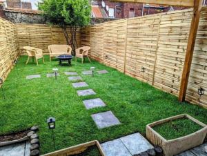 un pequeño patio trasero con una valla, una mesa y sillas en NG Prestige - Suite Soleil Doré - Balnéo - Cuisine - Jardin, en Roubaix