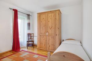 a bedroom with a bed and a wooden cabinet at Ampaillan 002 in Aosta