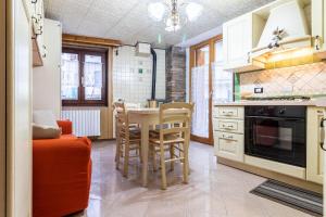 a kitchen with a table and chairs in a room at Casa Chechi tra Aprica e Ponte di Legno in Monno
