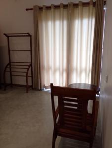 une chaise et une table dans une pièce avec une fenêtre dans l'établissement Crush River Villa Hikkaduwa, à Hikkaduwa