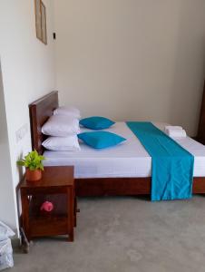 - une chambre avec un lit doté d'oreillers bleus et d'une table dans l'établissement Crush River Villa Hikkaduwa, à Hikkaduwa 20 autres photos